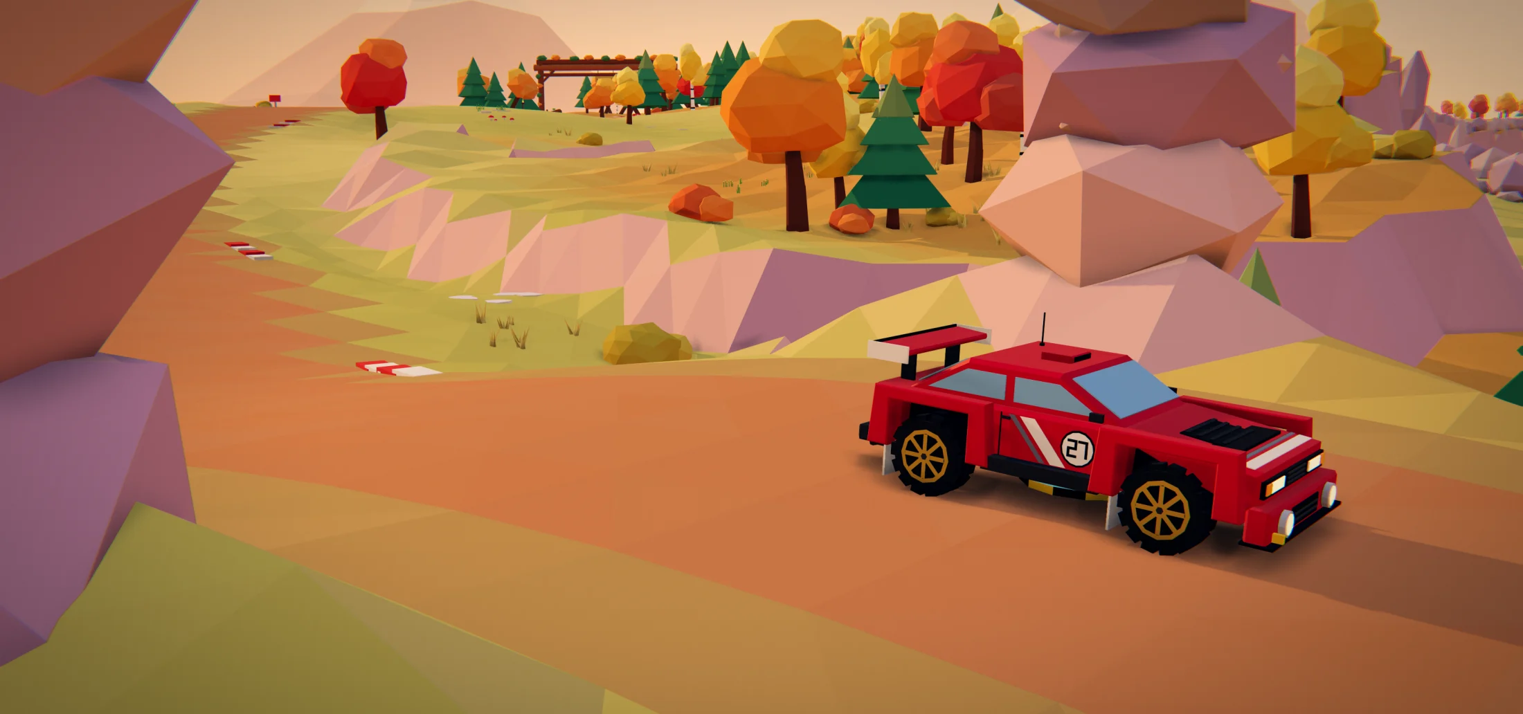 A red rally car on a dirt road through an autumn valley at sunset